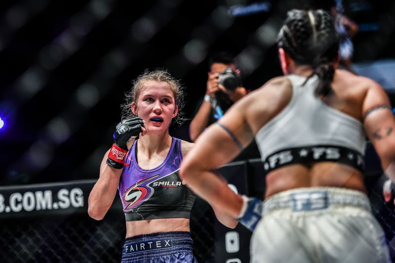 Smilla Sundell facing off with an opponent in the cage, both fighters wearing mouthguards