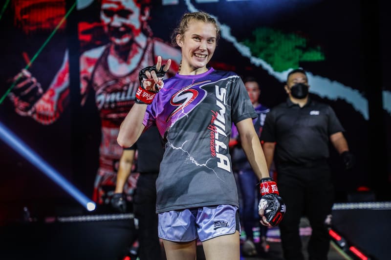 Smilla Sundell celebrating on stage in a grey "Smilla" branded t-shirt, pointing to the camera