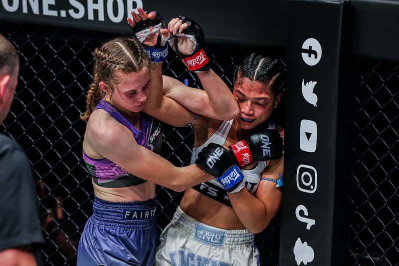 Smilla Sundell exchanging punches with an opponent against the cage fence