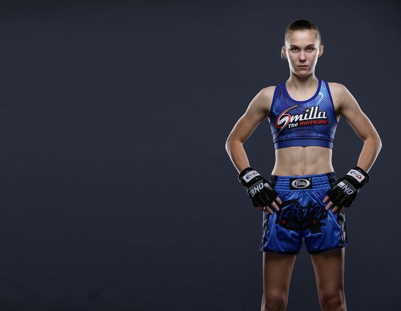 Studio portrait of Smilla Sundell in a blue "Smilla The Hurricane" fight kit, hands on hips
