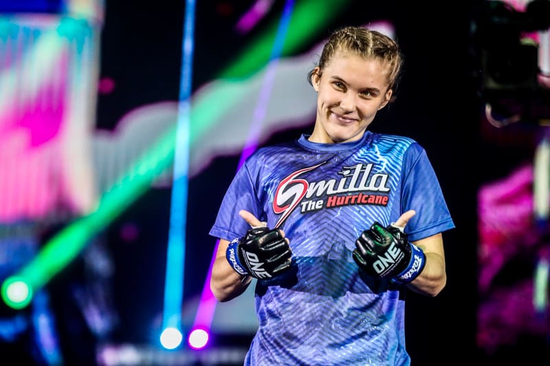 Smilla Sundell smiling on stage in her blue walkout jersey with gloved hands