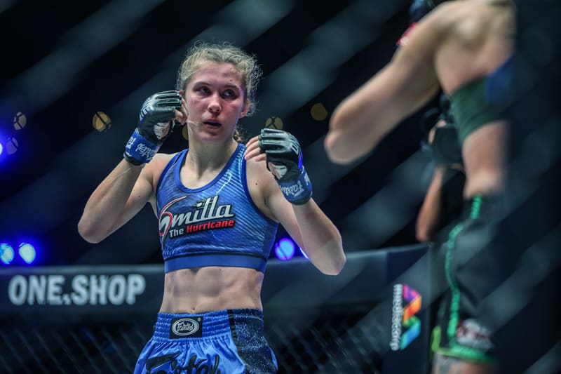Smilla Sundell facing an opponent across the cage in a blue "Smilla The Hurricane" fight kit